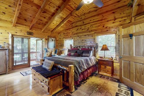 ein Schlafzimmer mit einem Bett in einer Blockhütte in der Unterkunft Lights Lodge in Blue Ridge