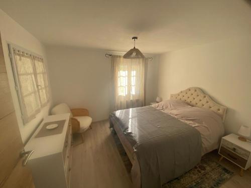 une chambre avec un lit, un bureau et une fenêtre dans l'établissement Maison de vacances, à Ongles