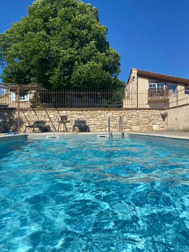 une grande piscine d'eau bleue avec un arbre en arrière-plan dans l'établissement Maison de vacances, à Ongles