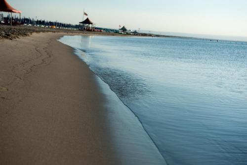 a beach with the ocean and a group of people at Stella Maris Hotel in Ginosa Marina