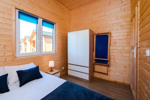 a bedroom with a bed in a wooden room at VIKING Gąski in Gąski
