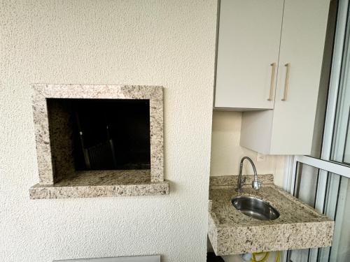 cocina con fregadero y espejo en la pared en Requinte e sofisticação a beira-mar, Beto Carrero, en Penha