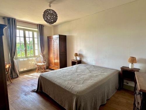 a bedroom with a bed and a large window at Vézelay, Maison de Marita in Vézelay