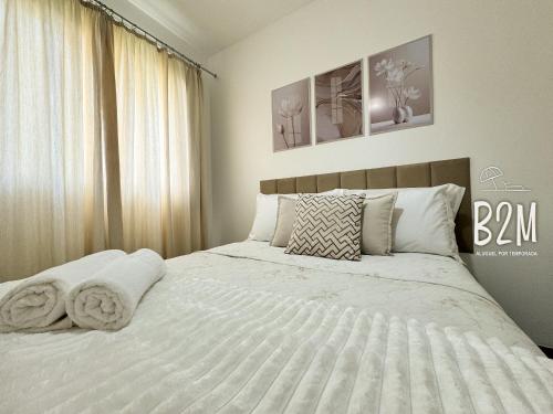 un dormitorio con una cama con sábanas y almohadas blancas en Requinte e sofisticação a beira-mar, Beto Carrero, en Penha