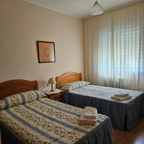 a hotel room with two beds and a window at Lhamo Mandala House in Pontevedra