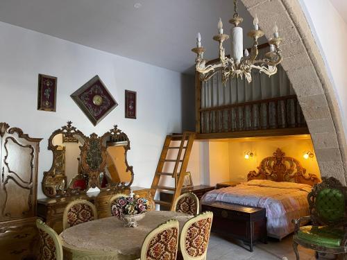 ein Schlafzimmer mit einem Bett und einem Tisch und Stühlen in der Unterkunft Kamara Cottage - Traditional Stone House in Malona Village