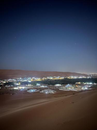a view of a beach at night with lights at zahr albun villa in Al Raka
