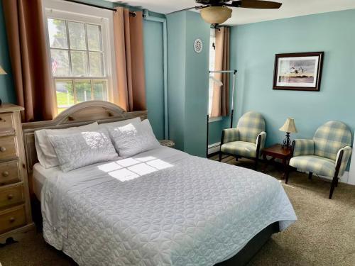 a bedroom with a white bed and blue walls at Hoppy Hill Farm House in Dover Plains