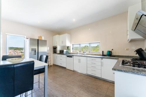 a kitchen with white cabinets and a counter top at Villa Moinhos da Costa in Foz do Arelho