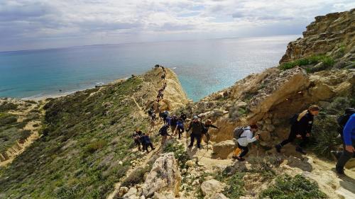 a group of people walking up a rocky mountain at Rantzo Holiday Apartments in Pissouri