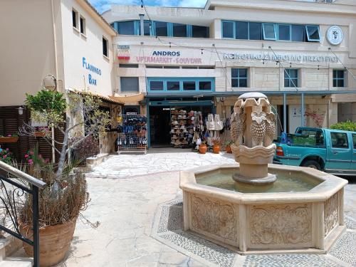 a fountain in a courtyard in front of a building at Rantzo Holiday Apartments in Pissouri
