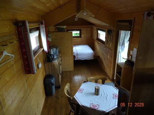 a room with a table and a bed in a tiny house at Tiny-house in Wihr-au-Val