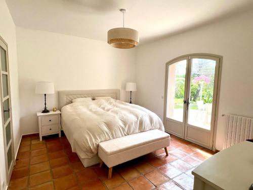 une chambre blanche avec un lit et une fenêtre dans l'établissement Belle Villa Mougins, à Mougins