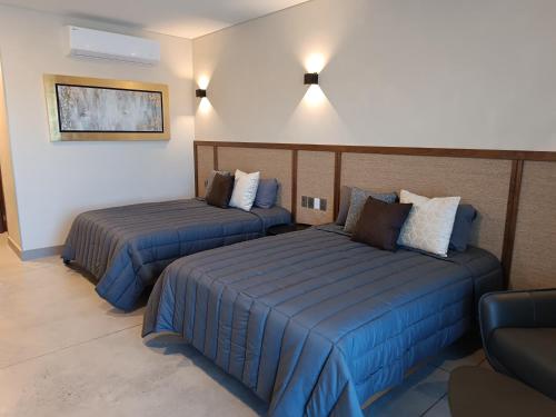 a hotel room with two beds and a couch at Hotel Zuma Colony in Querétaro