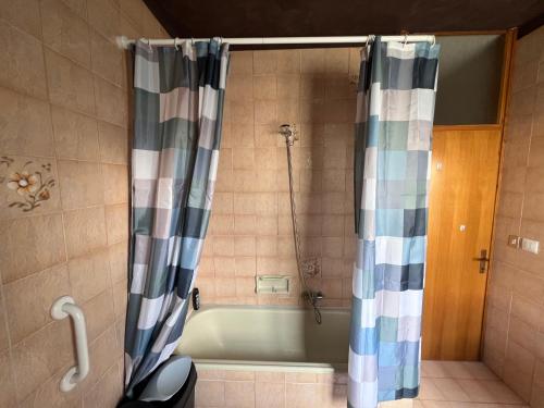 a bath tub with a shower curtain in a bathroom at Villa Gianfranca - sentiti come a casa in Corno di Rosazzo