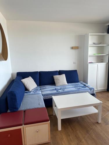un salon avec un canapé bleu et une table dans l'établissement Sisley 1061 - F2 Terrasse avec vue mer, à Cannes