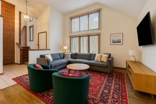 a living room with a couch and a table at Mountain Mojo Luxe Cabin Vibes in McGaheysville