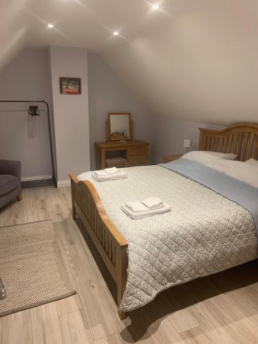 a bedroom with a bed with two towels on it at Bramble Cottage in Mickleton