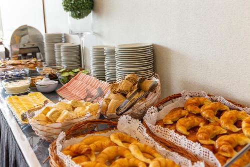 a buffet with baskets of bread and plates of food at Hotel Conte in Buenos Aires