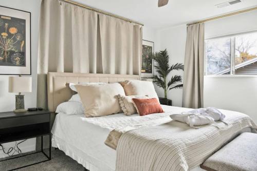 une chambre avec un lit blanc avec des oreillers et une fenêtre dans l'établissement The Songbird 99, à Redding