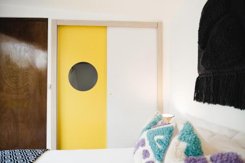 a bedroom with a yellow door and a window at The Gallery in Mexico City
