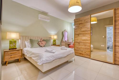 a bedroom with a large bed and a bathroom at Brand New apartment in central Msida by SF HOMES in Misraħ Il-Barrieri
