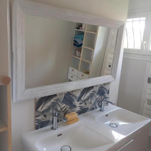 une salle de bain avec un lavabo blanc et un miroir dans l'établissement Havre de paix, mer et jardin luxuriant, à Fréjus