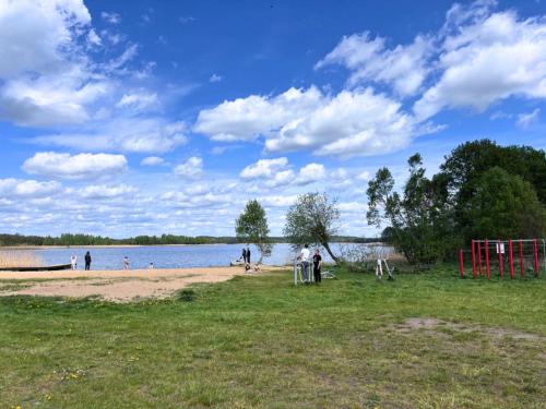 a group of people on a beach near the water at Apartament A - Rynek 4, Pasym in Pasym