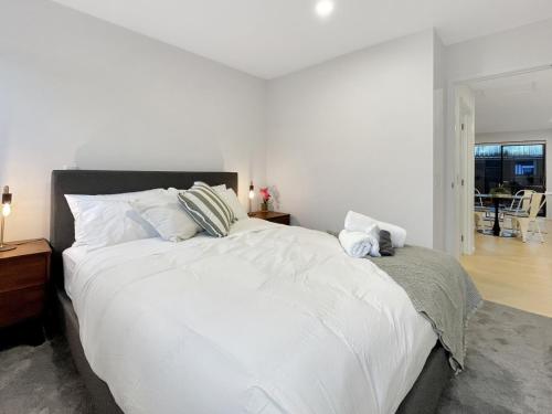 a bedroom with a large white bed with white pillows at Spacious Allen Street 1BR Stay in Christchurch