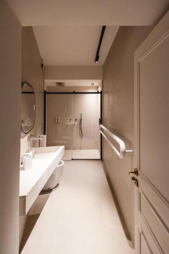Un baño con dos lavabos, un inodoro y una ducha. en Bianko EcoChic, en Enna