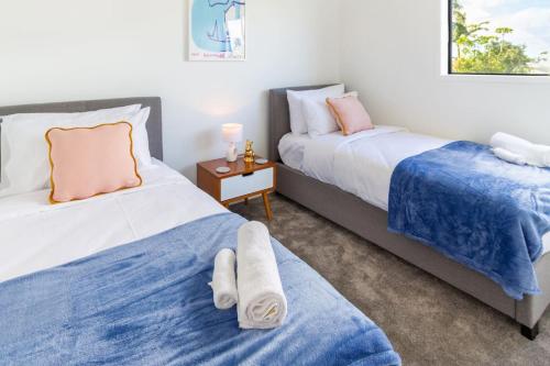 two beds sitting next to each other in a bedroom at Stunning Mount Albert 2 Bed in Auckland
