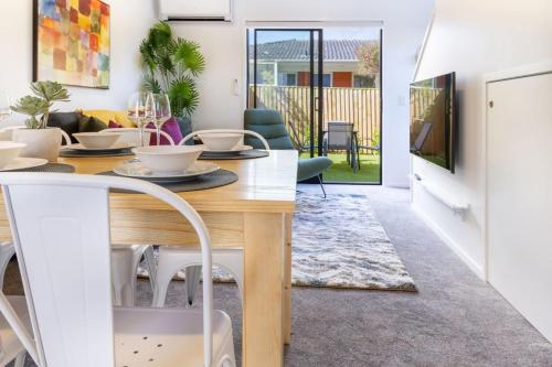 a living room with a dining room table and a living room at Stunning Mount Albert 2 Bed in Auckland