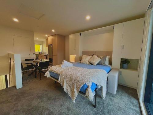 a bedroom with a large bed and a table at Spacious CBD 1-Bed 1-Bath in Christchurch