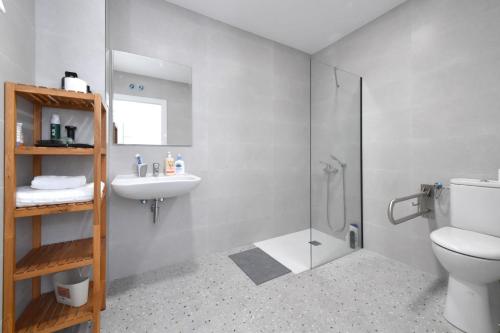 a bathroom with a shower and a toilet and a sink at Moebius - Habitaciones privadas con baño in León
