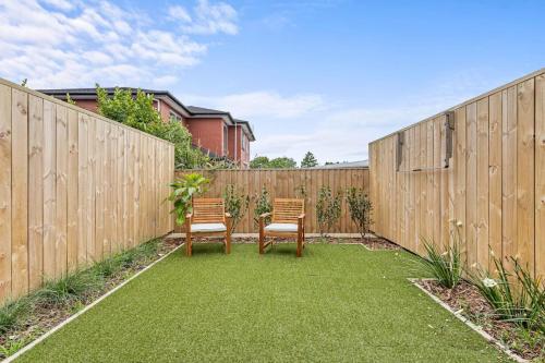 two chairs in a backyard with a fence at Alluring and Well-decorated Home in Auckland