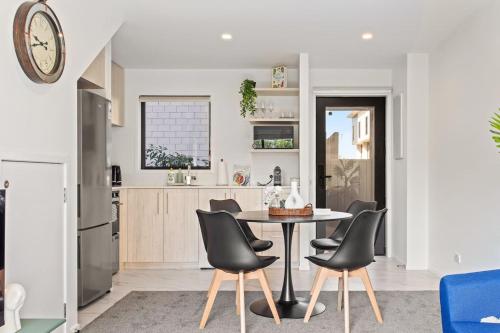 a kitchen and dining room with a table and chairs at Central Auckland Townhouse in Auckland