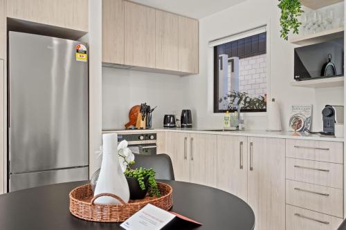 a kitchen with a table and a stainless steel refrigerator at Central Auckland Townhouse in Auckland