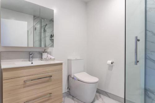 a bathroom with a toilet and a sink and a shower at Comfortable Family Home in Auckland
