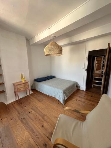 une chambre avec un lit, une table et une chaise dans l'établissement maison charmante village, à Gruissan
