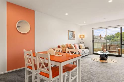 une salle à manger avec une table et un canapé dans l'établissement Well-styled Vibrant 2 Bed Home, à Auckland