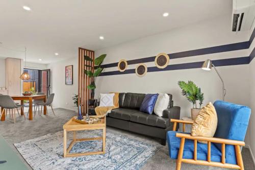 a living room with a couch and a table at Warm and Bright 2 Bed Townhouse in Auckland