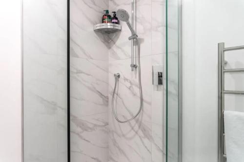 a bathroom with a shower with a glass door at Warm and Bright 2 Bed Townhouse in Auckland