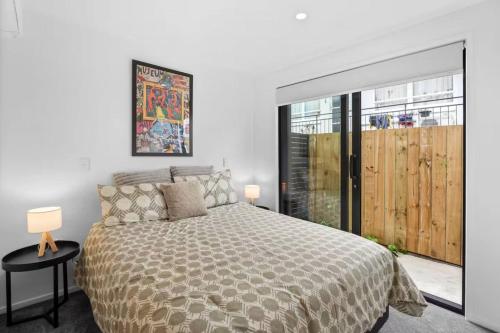a bedroom with a bed and a large window at Beautiful Bay of Plenty 2 Bed in Tauranga