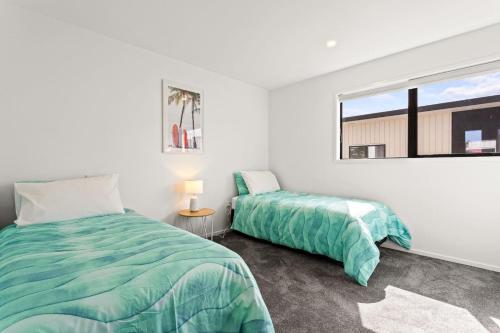 a bedroom with two beds and a window at Perfect For You and Your Family in Auckland