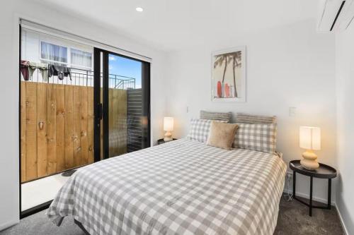 a bedroom with a bed and a large window at Vibrant Tauranga 2 Bed 2 Bath in Tauranga