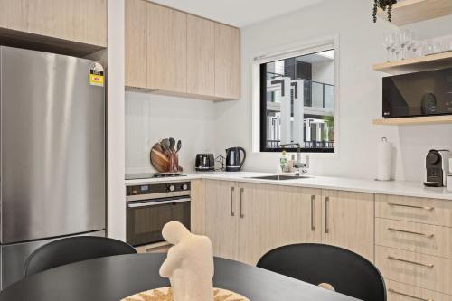 a kitchen with a black table and black chairs at Charming 2 Bed Family Home in Auckland
