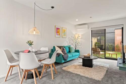 a living room with a blue couch and a table at Charming 2 Bedroom Family Home in Auckland