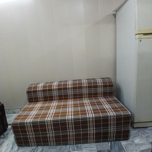 a couch sitting in the corner of a room at Elegant Single Bedroom Islamabad in Islamabad