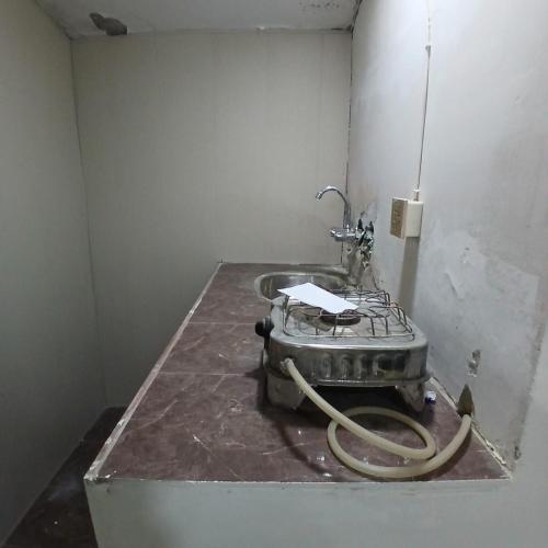 a bathroom with a sink with a hose at Elegant Single Bedroom Islamabad in Islamabad