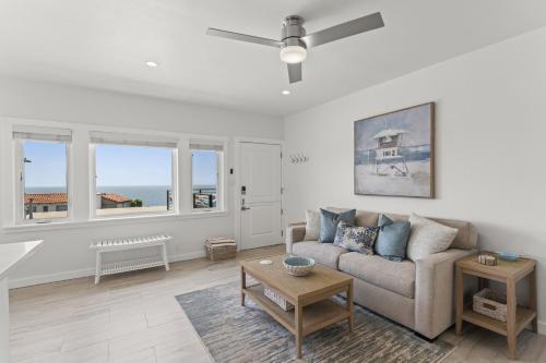 a living room with a couch and a table at Penthouse Steps from Victoria Beach 180 degree ocean views in Laguna Beach